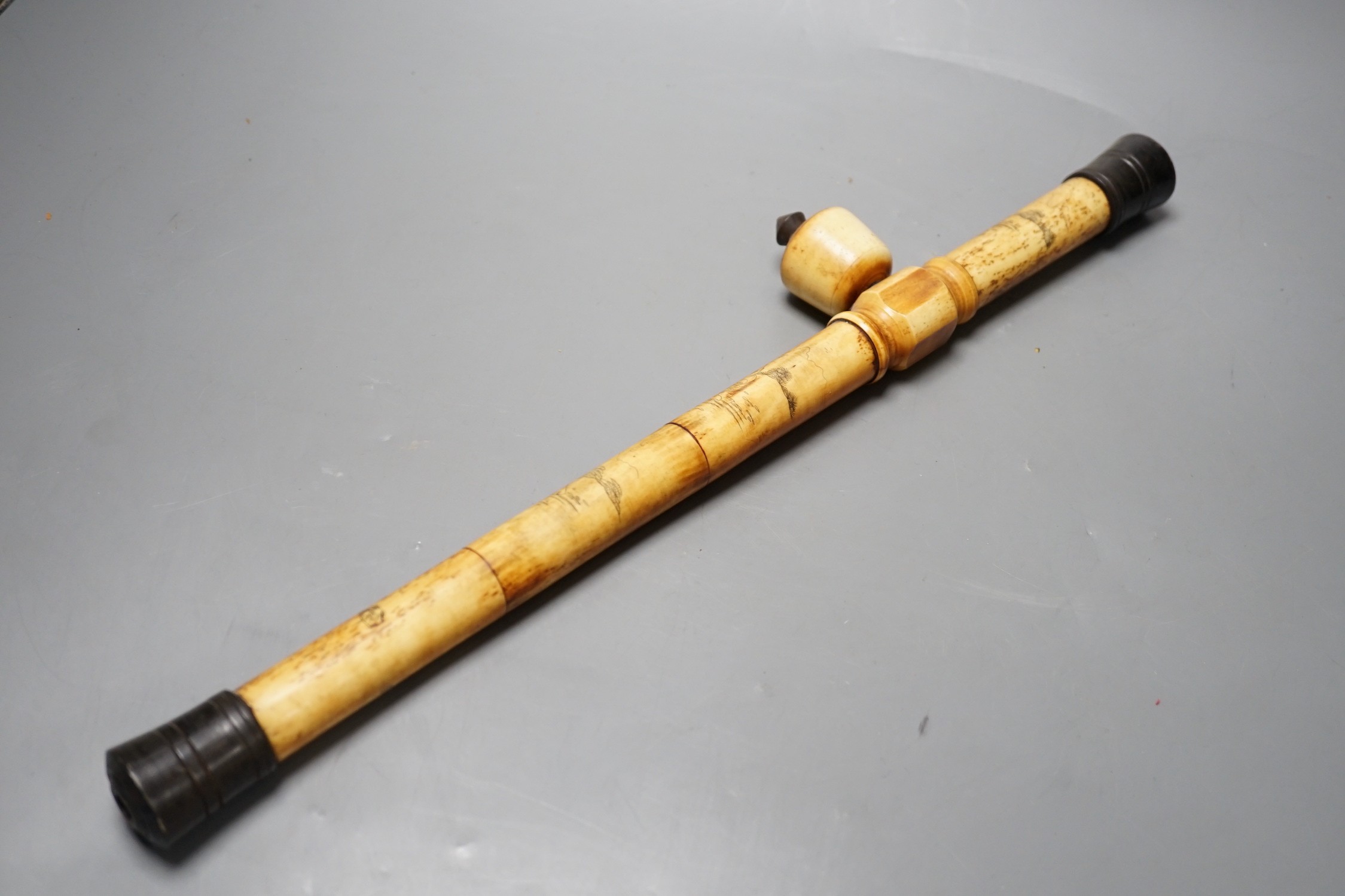 A Chinese bone opium pipe with figural decoration, 46cm wide